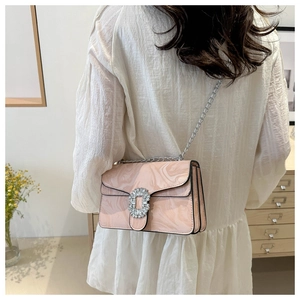 Detailed view of pink marble patterned bag with silver rhinestone buckle and chain strap