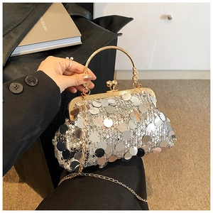 Detail of silver sequin evening bag featuring a gold spherical clasp and round metal handle
