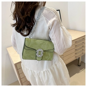 Detail of green marble pattern leather bag with crystal buckle and silver chain
