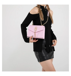 Détail du sac bandoulière rose embossé croco avec boucle dorée et chaîne sur mannequin