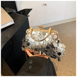 Detail of vintage silver sequin handbag featuring gold metal handle and retro clasp