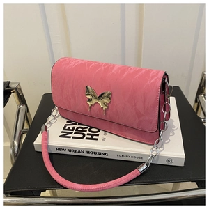 Detailed shot of pink pleated shoulder bag featuring a metallic butterfly buckle and chain