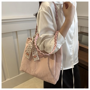 Detail of pink tote bag with woven strap, floral scarf accent and fashion triangle logo