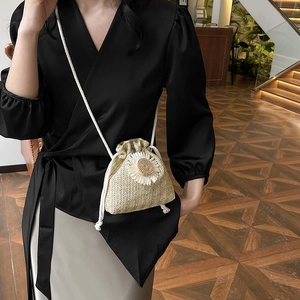 Beige straw bucket bag with daisy flower and cotton rope strap for beach vacation