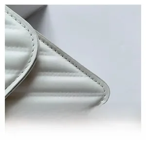 Detail shot of white quilted PU leather with horizontal stitching on a minimalist bag