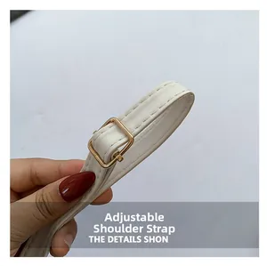 Close-up of adjustable white leather strap with premium gold metal buckle for shoulder bag