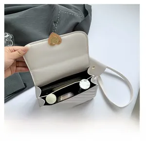 Interior view of white crossbody bag with heart-shaped gold lock and daily essentials