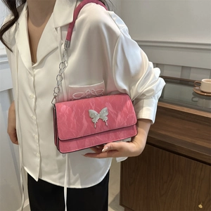 Pink marble leather shoulder bag with silver butterfly and chain strap on model