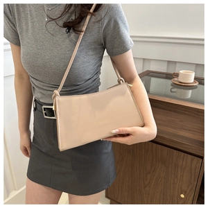 Sac à bandoulière beige chic avec lettrage Fashion doré dans un décor urbain élégant