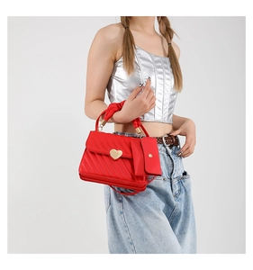 Detail of red quilted handbag with golden heart clasp and matching coin purse