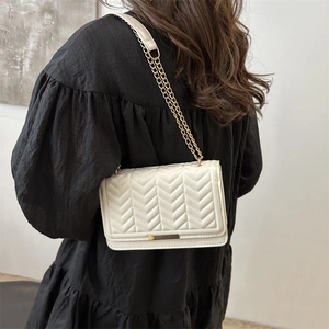 White quilted shoulder bag with gold chain strap and elegant chevron stitching design