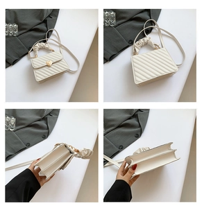 Detail of white quilted crossbody bag with heart buckle and pleated cloud handle