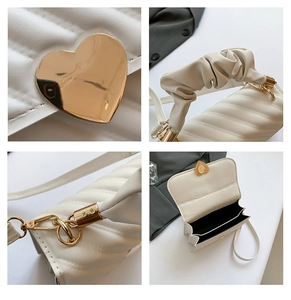 Detailed view of white quilted bag with heart-shaped gold lock and scrunchie handle