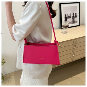 Sac à bandoulière rose fuchsia avec texte doré et détail de nœud sur la lanière