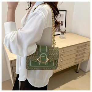 Detail of vintage green woven chain bag with gold oval clasp shown on model