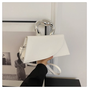 Detail of white leather handbag with fluid silver metal handle and asymmetric flap