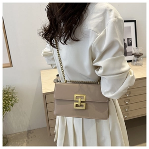Detailed view of apricot leather shoulder bag with vintage gold chain and geometric clasp