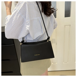 Dettaglio della borsa a tracolla nera in ecopelle con scritta dorata FASHION di tendenza