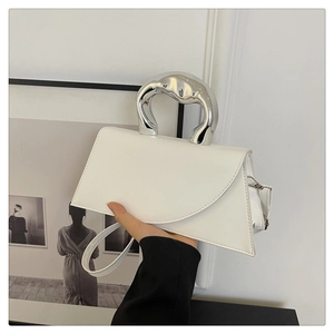 Detail of white leather handbag featuring a unique liquid silver metal top handle