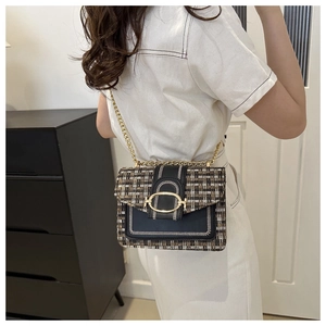 Crossbody view of a vintage tweed flap bag with gold chain strap and metal buckle