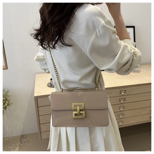 Detail of elegant beige minimalist crossbody bag with vintage interlocking gold buckle