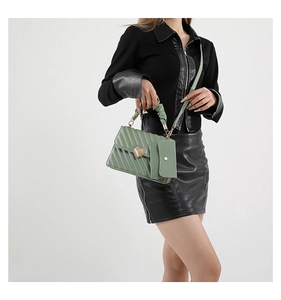 Detail of sage green quilted crossbody bag with heart lock and small matching purse