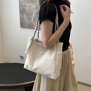 Chic beige pleated tote bag with woven shoulder straps and floral silk scarf detail