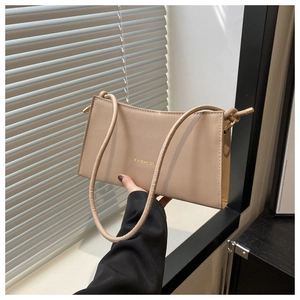 Détail du sac à bandoulière beige avec texte Fashion doré et fine lanière en cuir