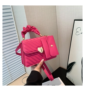 Macro detail of magenta quilted PU leather bag with gold heart lock and pleated handle