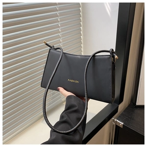 Détail du sac porté épaule en cuir noir mat avec lettrage FASHION doré et boucle en métal