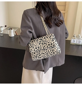 Close-up of leopard print tote bag featuring a gold chain strap and stylish flap closure