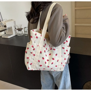 Détail du sac cabas en velours côtelé blanc avec fraises rouges et poches