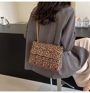Close-up of leopard print tote bag with a gold metal chain strap on a model shoulder