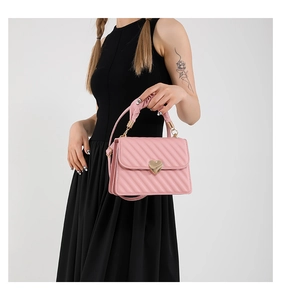 Detail of pink quilted handbag with heart lock, cloud handle and adjustable strap