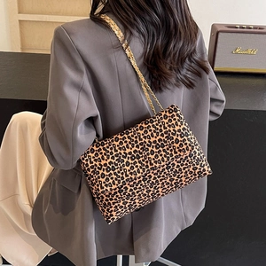 Chic leopard print flap shoulder bag with gold chain strap on a stylish model