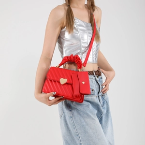 Red PU leather crossbody bag with heart lock and gathered cloud handle shown on model