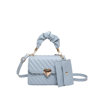 Quilted light blue shoulder bag with heart clasp, scrunchie handle, and small pouch