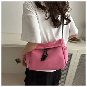 Rear view of model wearing pink nylon crossbody bag showing size and casual style
