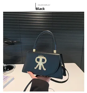 Detailed view of black leather crossbody bag with gold RR logo and top handle