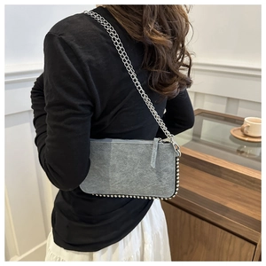 Detail of grey washed denim shoulder bag with silver beaded trim and double chain strap