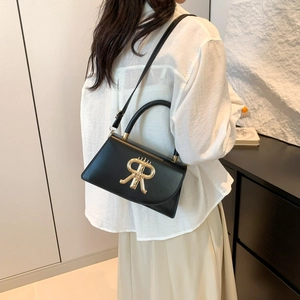 Modern black crossbody bag with gold R-logo clasp and adjustable shoulder strap