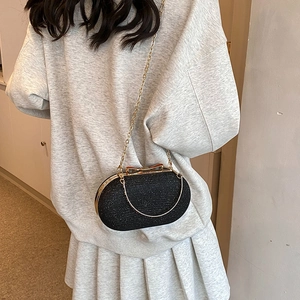 Elegant black glitter crossbody bag with gold bow clasp and metal chain strap for women