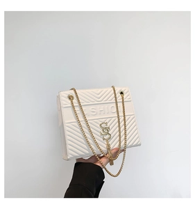 Détail du sac bandoulière blanc matelassé avec chaîne dorée et pendentif à pampilles