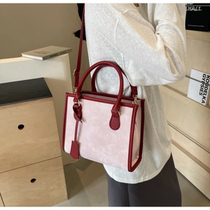 Mannequin portant un sac cabas en cuir rose et rouge avec bandoulière réglable