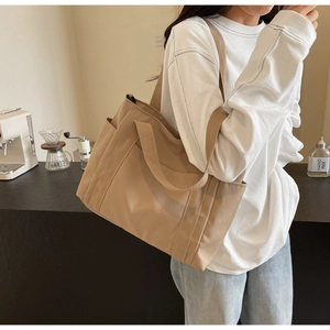 Dettaglio della tasca laterale e della trama in tela ad alta densità della borsa beige