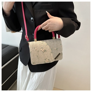 Détail du sac à main en paille beige avec broderie florale et anses tressées rose vif