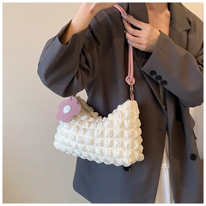 Detail of cream pleated tote bag with pink rope handle and flower charm decoration