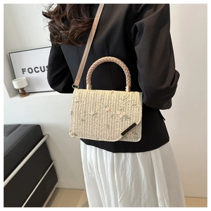 Détail du sac à main en paille avec broderies florales et bandoulière en cuir amovible