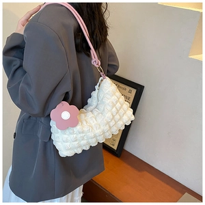 Detail of white bubble texture tote bag with pink flower charm and soft shoulder strap