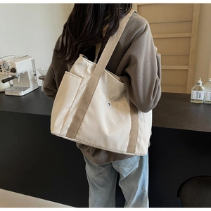 Dettaglio della borsa tote in tela bianco sporco con spalline larghe e tasche laterali